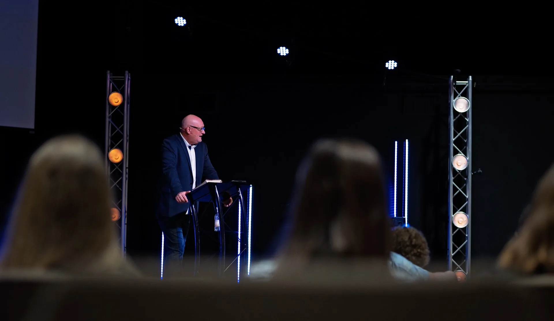 Pastor preaching on the Victory Church stage